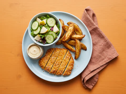 Sesame chicken schnitzel with wedges and salad